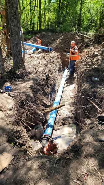 Angelina workers laying pipe in a trench