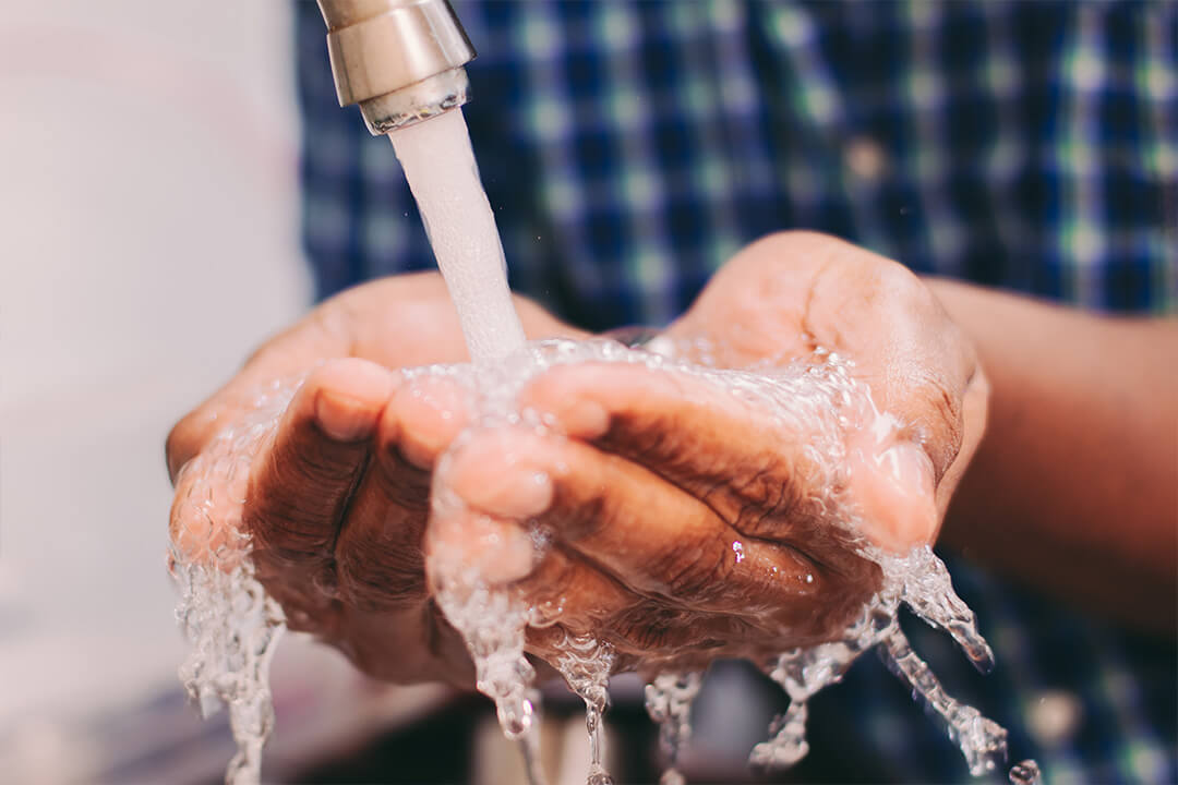 Person washing hands in clean water